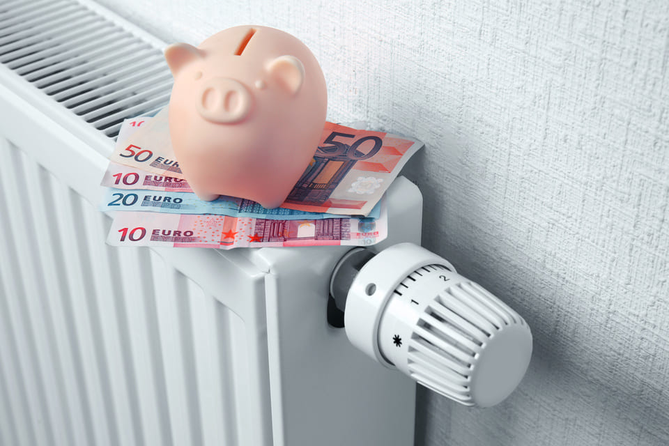 Tirelire avec plusieurs billets sur un radiateur