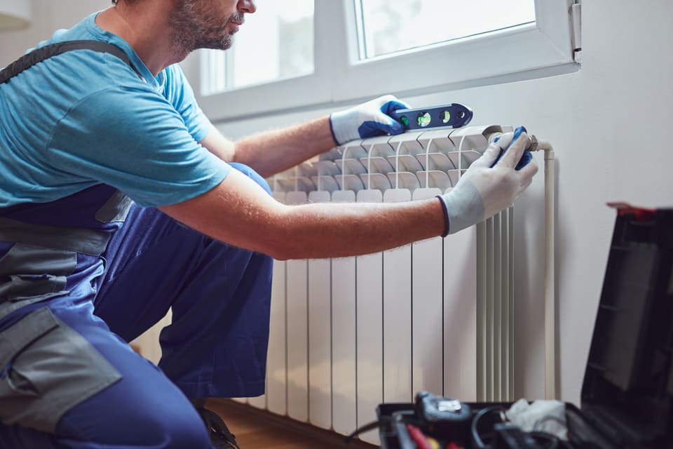 Pose d'un nouveau radiateur dans un salon